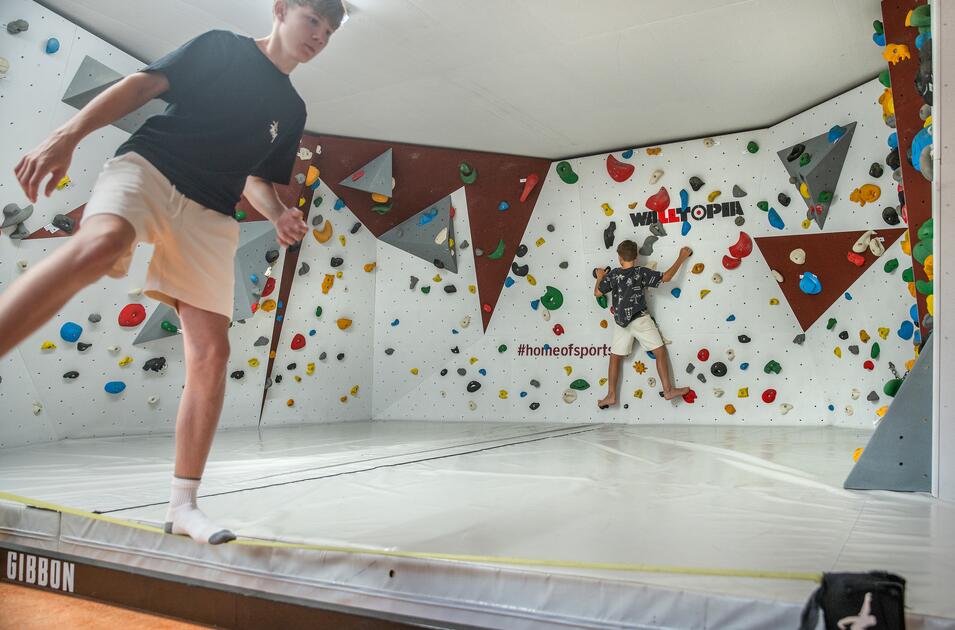 Kinder klettern in Boulder-Halle