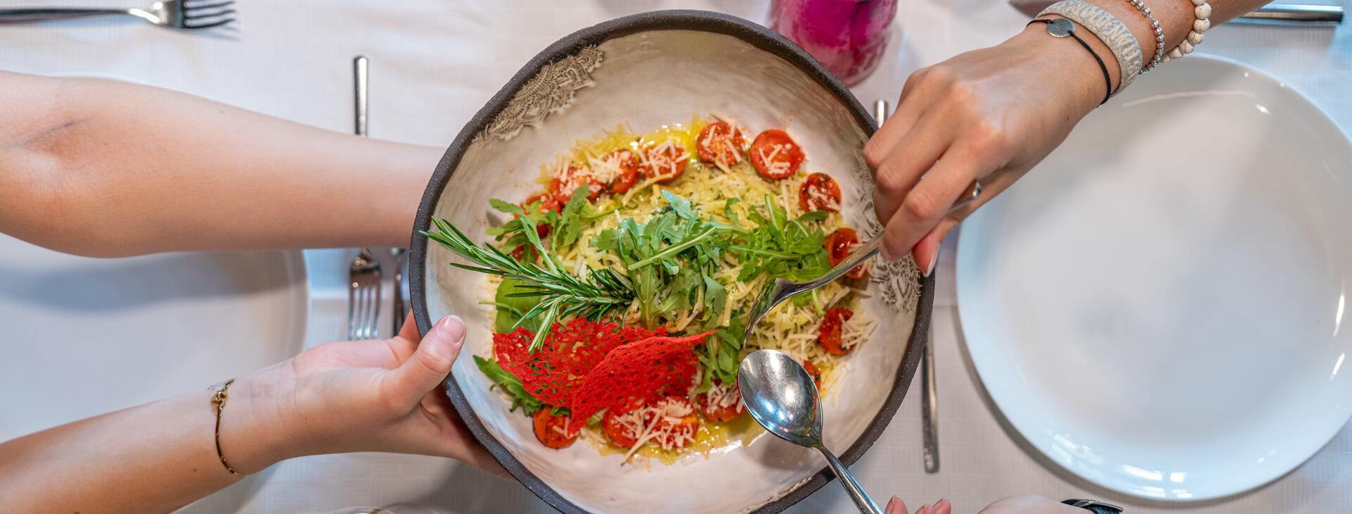 Risotto garnished with tomatoes and rucola