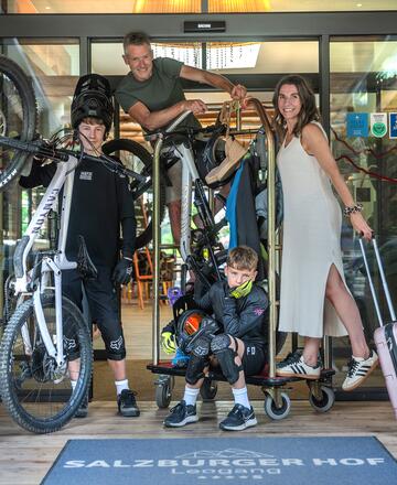 Familie steht mit Mountainbike Ausrüstung vor dem Hotel Salzburger Hof