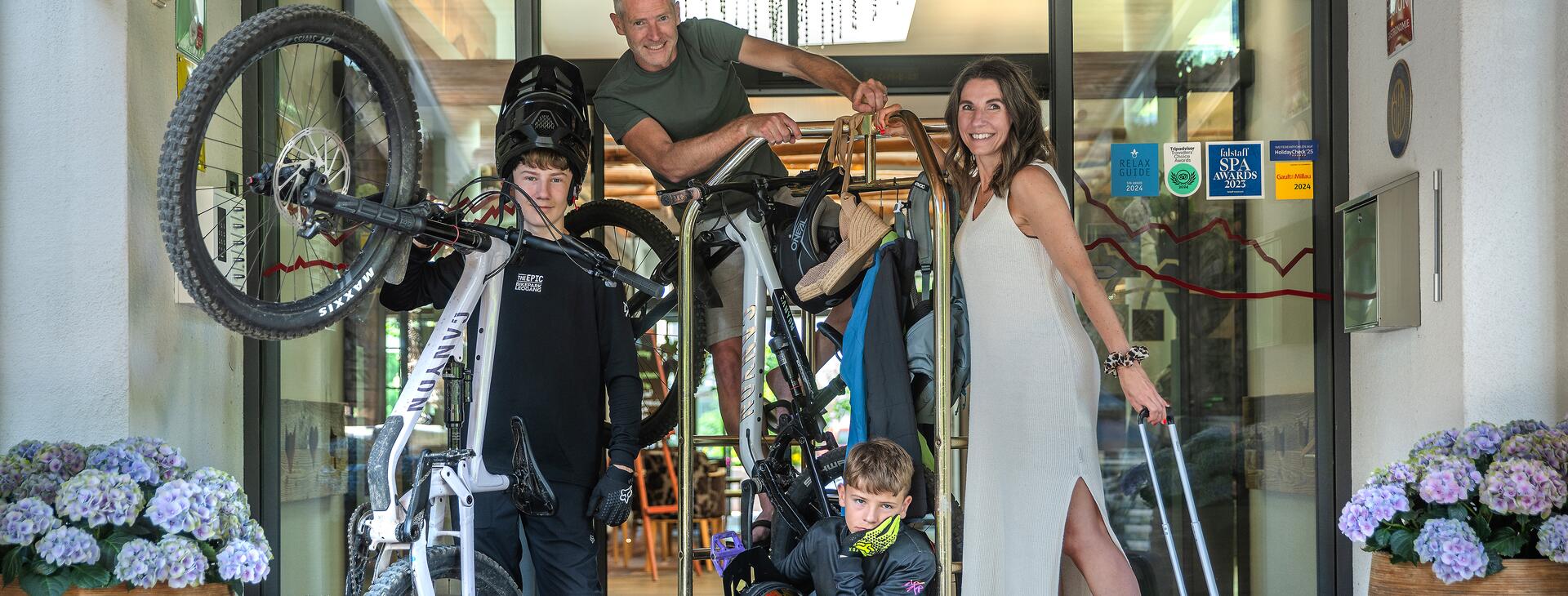 Familie steht mit Mountainbike Ausrüstung vor dem Hotel Salzburger Hof
