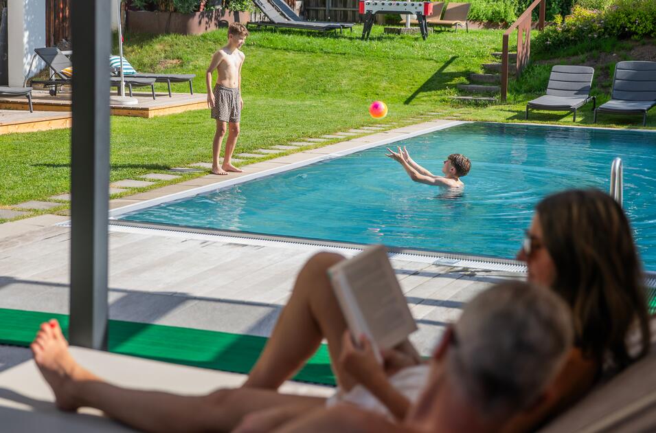 Kinder spielen mit Ball im Gartenpool 