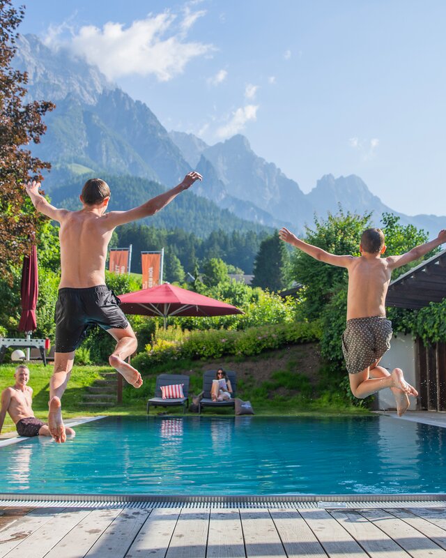 Children jumping into the garden pool
