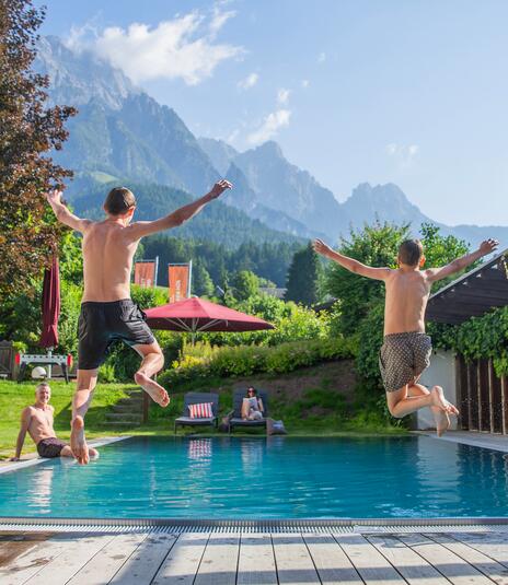Children jumping into the garden pool