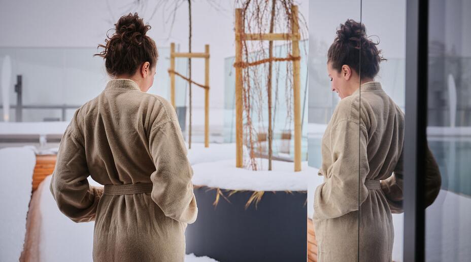 Frau im Bademantel am verschneiten Infinty-Pool