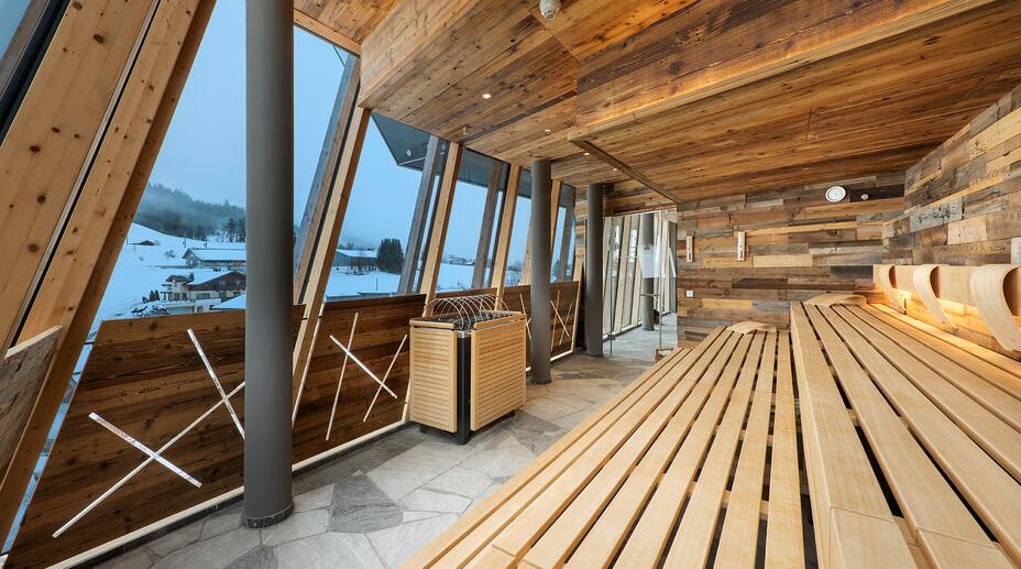 Panoramic sauna with a view of the snow-covered landscape.