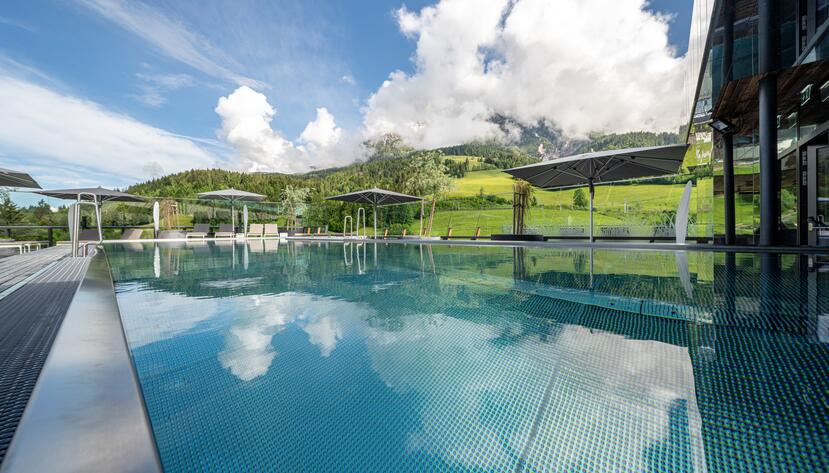 Au&szlig;enpool vor bew&ouml;lkter Berglandschaft