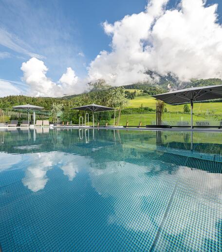 Außenpool vor bewölkter Berglandschaft