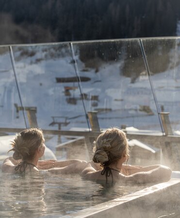 Two women in the infinity pool in winter.
