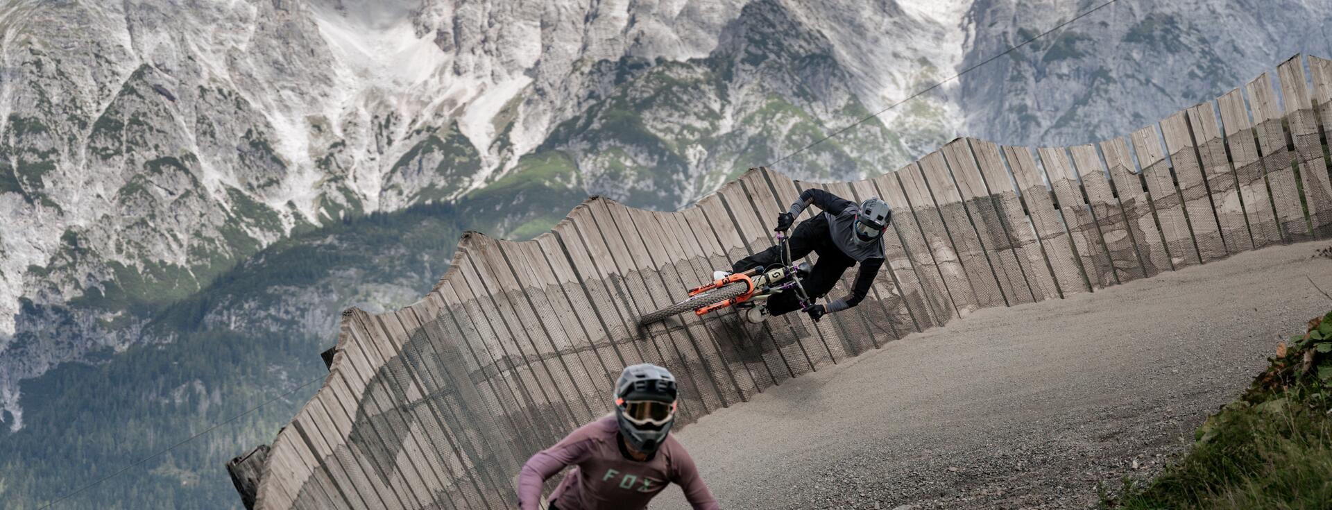 Biker im Wallride im Bikepark Leogang mit Bergkulisse