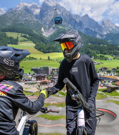 Zwei Kinder in voller Montur stehen über dem Bikepark Leogang 