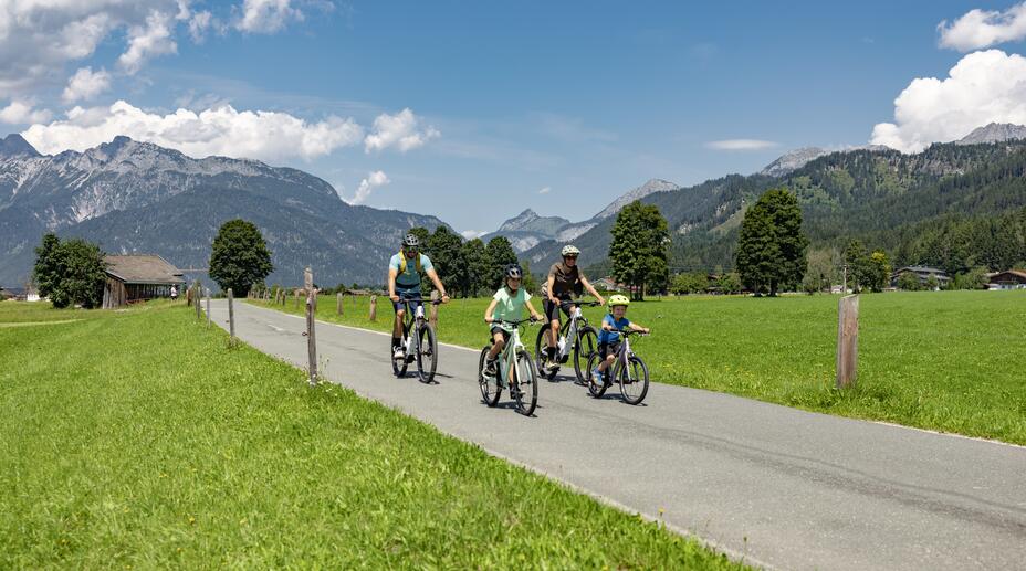 Family riding mountain bikes along a country road