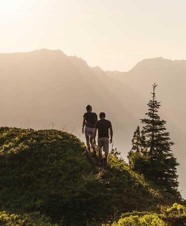 Hiker on a mountain trail at sunrise